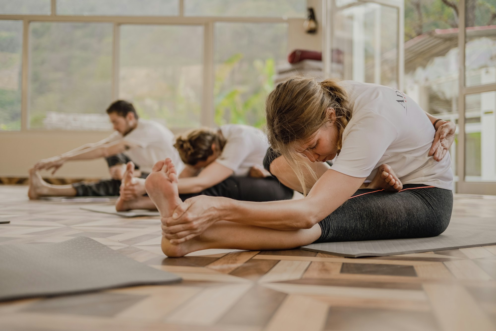 Small group mat Pilates class in a warm, sunlit studio